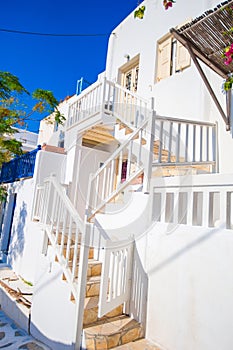 The narrow streets of the island with blue balconies, stairs and flowers.