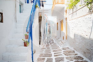 The narrow streets of the island with blue balconies, stairs and flowers.