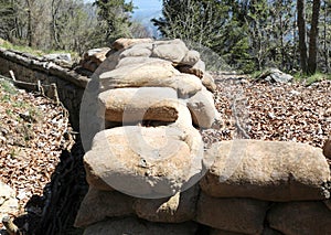 narrow trench dug in the ground with sandbags to protect soldiers from enemy attacks photo