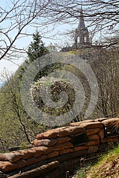 narrow trench dug in the ground and  view of the Monte Cimone ossuary in Northern Italy photo