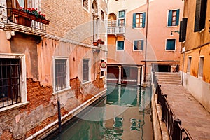 Narrow Venetian water street between red brick houses