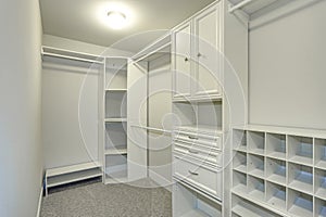 Narrow walk-in closet lined with built-in drawers