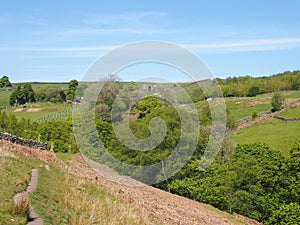 A narrow path on high moorland surrounded by pasture with stone walls above crimsworth dean valley in west yorkshire