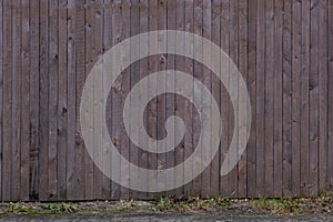 A narrow wooden board fence