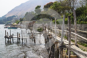 Narrow wooden bridge and docks along lake Atitlan at the coast of Santa Cruz la Laguna, Guatemala