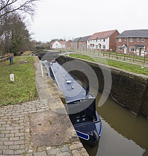Narrowboat in a lock on a British canal in rural setting