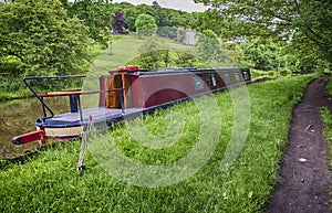 Narrowboat moored on a British canal in rural setting