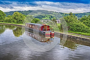 Narrowboat moored on a British canal in rural setting