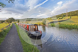 Narrowboat moored on a British canal in rural setting