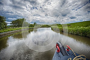 Narrowboat traveling on a British canal in rural setting