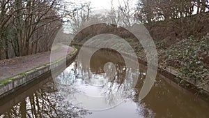 Narrowboat traveling on a British canal in rural setting