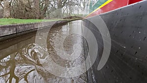 Narrowboat traveling on a British canal in rural setting