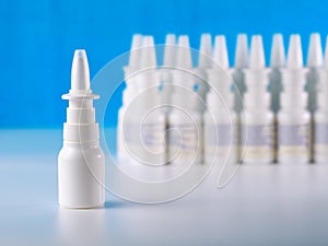 Nasal spray bottle in front of other bottles row photo