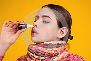 The nasal spray. Female in scarf using nasal spray medicine for runny nose. Nasal spray for allergic rhinitis, cold