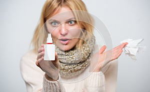 Nasal spray using. Cute woman nursing nasal cold or allergy. Unhealthy girl with runny nose using nasal spray. Treating