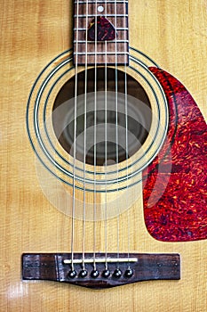 Nashville Acoustic Guitar Sound Hole, strings and Pick with detail of wood grain, pick guard and bridge