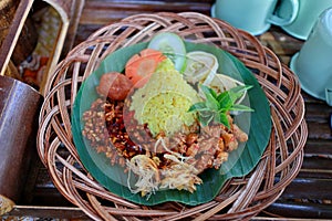 Nasi Kuning. Javanese turmeric rice with assorted side dishes photo