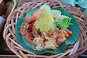 Nasi Kuning. Javanese turmeric rice with assorted side dishes photo