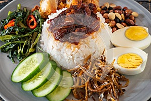 Nasi Lemak is a rice dish infused with coconut cream and laden with deep-fried fish or fried chicken.