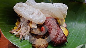 Nasi liwet with tempe tofu egg chicke and rice crisp on banana leaf