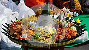 Nasi tumpeng (cone rice) served with urap-urap (Indonesian salad), fried chicken and noodles