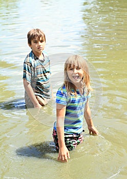 Nasty kids in clothes soaking wet in water photo