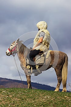 National clothes of Georgian shepherds burka and hat against mountains. Georgia