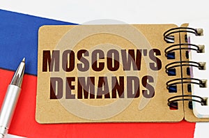 On the flag of Russia lies a pen and a notepad with the inscription - Moscows demands