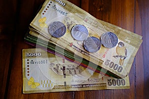 national currency of Sri Lanka, paper money bills 5000 Rupee banknotes, coins on wooden table, devaluation, high inflation of