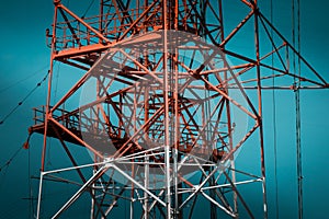 National Energy Grid system. Power pylons connecting the country. Red steel structures on deep blue sky