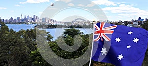 The National flag of Australia flay along Sydney skyline