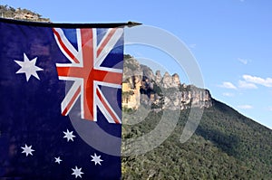 The National flag of Australia flay beside the Three Sisters Blu