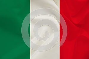The national flag of the country of Italy on gentle silk with wind folds, travel concept, immigration, politics, copy space, close