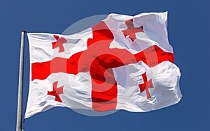 National flag of Georgia against the blue sky.