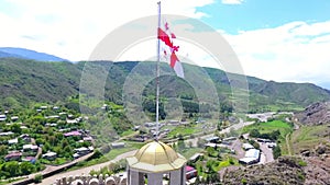 National flag of Georgia on flagpole in front of blue sky. Three dimensional rendering 3D animation.