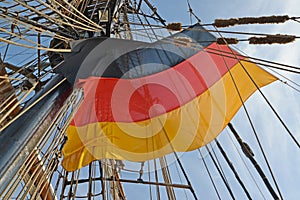 National flag of Germany flutters among tackles of the sailing vessel