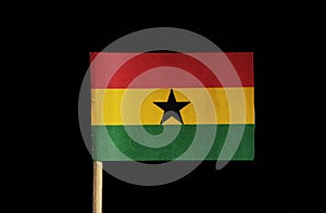 A national flag of Ghana on toothpick on black background. A horizontal triband of red, gold and green with a black star in centre