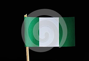 A national flag of Nigeria on toothpick on black background. Nigerian flag contain green and white colour.
