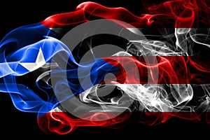 National flag of Puerto Rico made from colored smoke isolated on black background. Abstract silky wave background.