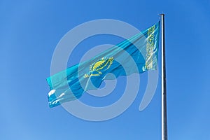 The national flag of the Republic of Kazakhstan (Qazaqstan) flutters in the wind