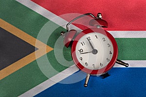 National flag of Republic of South Africa and vintage alarm clock, close up