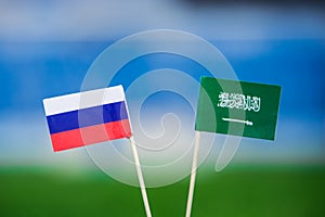 National flag of Russia and Saudi Arabia on Football pitch. Football ball on green grass