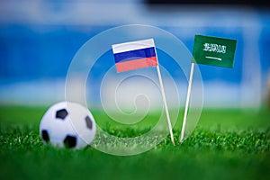 National flag of Russia and Saudi Arabia on Football pitch. Football ball on green grass