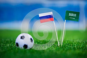 National flag of Russia and Saudi Arabia on Football pitch. Football ball on green grass