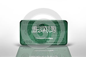 National flag of saudi arabia on the dollar money banknote on the white background