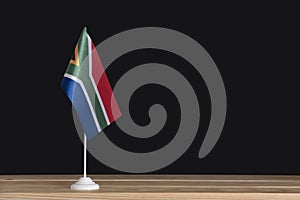 National flag of South Africa on table, black background. Flag pole. Copy space