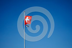 National flag of switzerland and kosova with blue sky background
