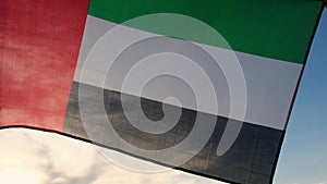 National Flag Of UAE Waving In The Wind sunset. Flag of United Arab Emirates on Sun Background. Sign of Dubai. National