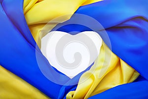 National flag of Ukraine in form of heart. Fabric curved flag in yellow-blue colour in heart-shaped on white background.
