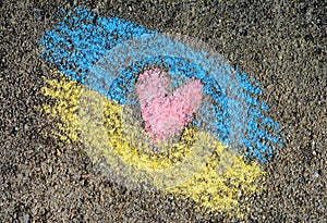 National flag of Ukraine with heart drawn by color chalk on asphalt, top view
